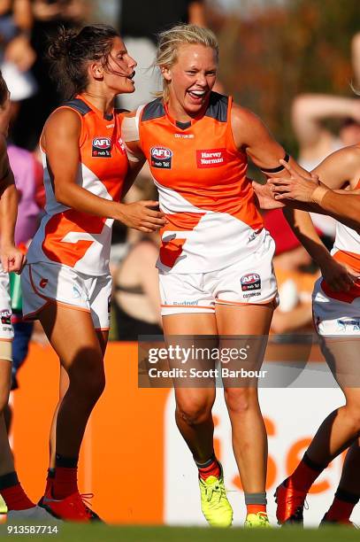 Phoebe McWilliams of the Giants is congratulated by her teammates after kicking a goal during the round one AFLW match between the Melbourne Demons...