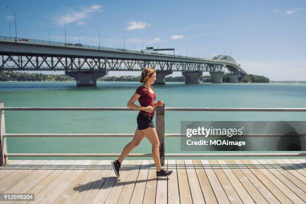 a young caucasian girl exercises at the auckland seaside - coordinated effort stock pictures, royalty-free photos & images