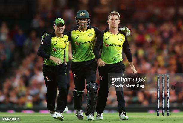 Adam Zampa of Australia celebrates with David Warner and Alex Carey of Australia after taking the wicket of Tom Blundell of New Zealand during game...