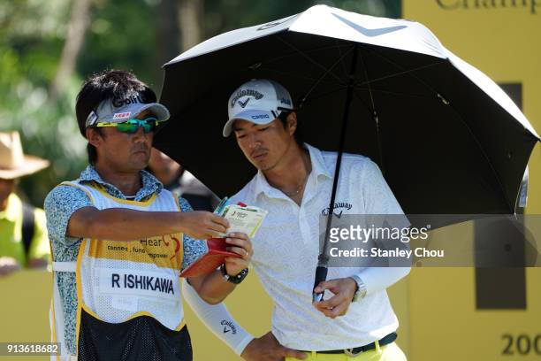 Ryo Ishikawa of Japan speaks with his caddie during day three of the 2018 Maybank Championship Malaysia at Saujana Golf and Country Club on February...