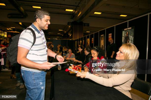 Actress Pamela Anderson signs autographs as she attends the '25th Paris Manga & Sci-Fi Show' at Parc des Expositions Porte de Versailles on February...