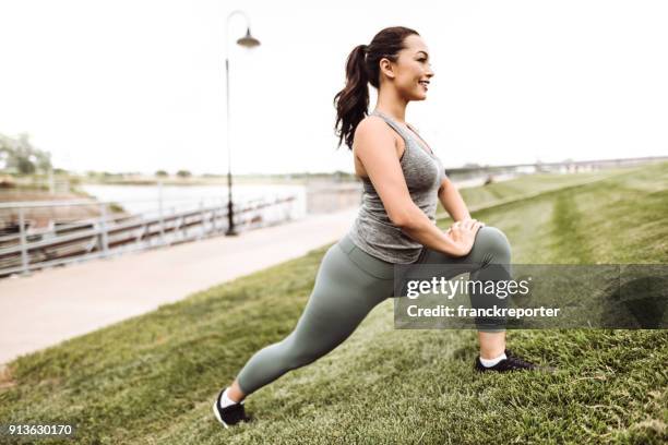 femme de remise en forme qui s’étend dans l’herbe - cute chubby women photos et images de collection