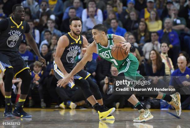 Jayson Tatum of the Boston Celtics drives towards the basket on Stephen Curry of the Golden State Warriors during an NBA basketball game at ORACLE...