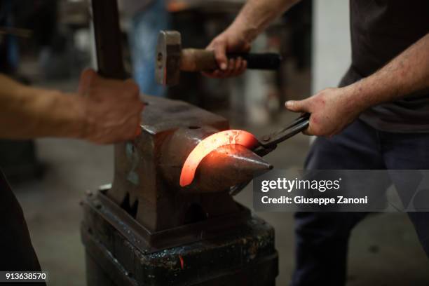 farrier forging horseshoe on anvil - blacksmith farrier stock pictures, royalty-free photos & images