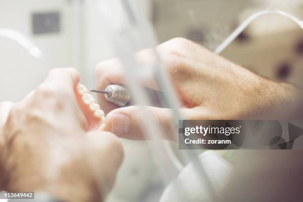 polishing dentures in dental laboratory - dentures stock pictures, royalty-free photos & images