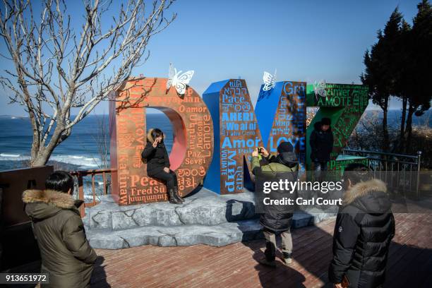 Tourists pose for photographs next to a sculpture spelling out the acronym 'DMZ' at the Korean Demilitarized Zone by Goseong Unification Observatory...