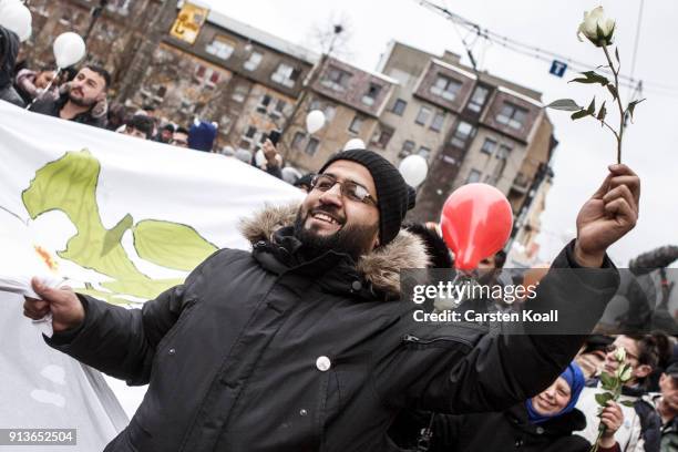 Man holds a rose as refugees and supportive locals march under the motto "Live Without Hate" in the city center to protest for peaceful co-existence...