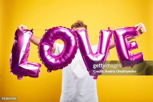 man holding letters on color background - tshirt mockup stock pictures, royalty-free photos & images