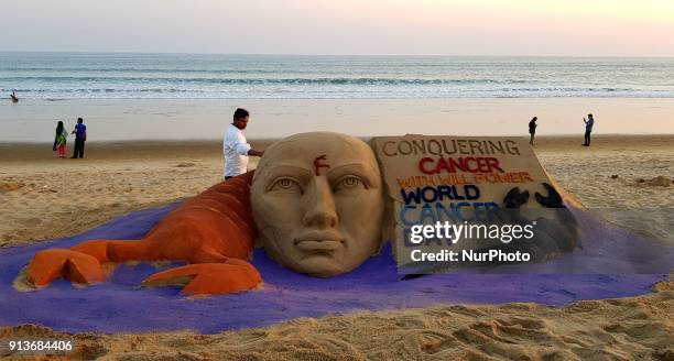 Cancer awareness sand sculpture is seen at the Bay of Bengal Sea's eastern coast beach at Puri, creating by Indian sand artist Manas Sahoo for...