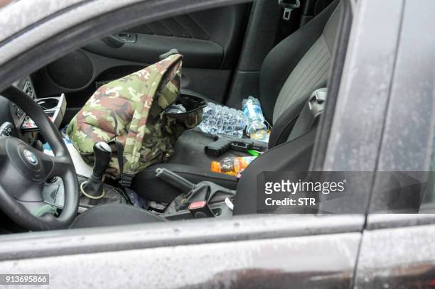 Glock handgun sits on the seat of a black Alfa Romeo used by a man suspected of wounding several foreign nationals in a drive-by shooting,is blocked...