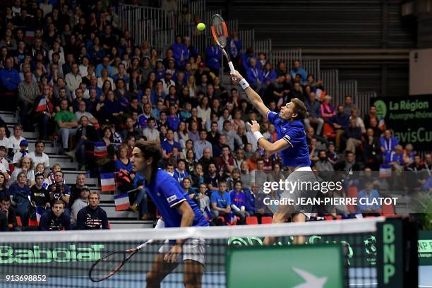 France's Nicolas Mahut , flanked by his teammate Pierre-Hugues Herbert hits a return against Netherlands' double Jean-Julien Rojer and Robin Haase...