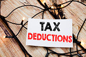 Handwritten text caption showing Tax Deductions. Business concept writing for Finance Incoming Tax Money Deduction written on sticky note paper on the wooden background.