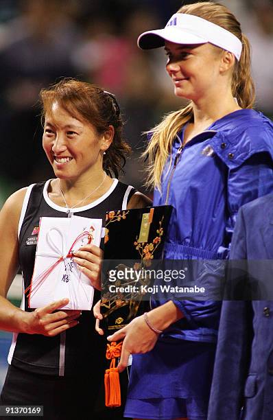 Ai Sugiyama of Japan and Daniela Hantuchova of Slovakia pose with the trophies after playing their doubles final match against Francesca Schiavone of...