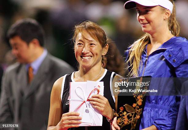 Ai Sugiyama of Japan and Daniela Hantuchova of Slovakia pose with the trophies after playing their doubles final match against Francesca Schiavone of...