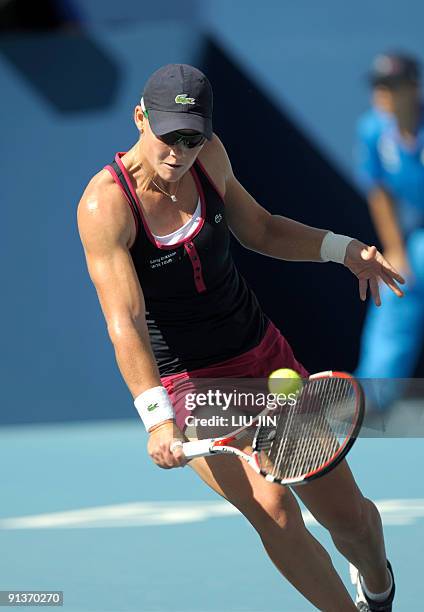 Samantha Stosur of Australia hits a return to Alize Cornet of France during their first round match of the China Open 2009 at the National Tennis...