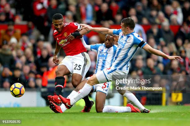 Terence Kongolo of Huddersfield Town tackles Antonio Valencia of Manchester United during the Premier League match between Manchester United and...