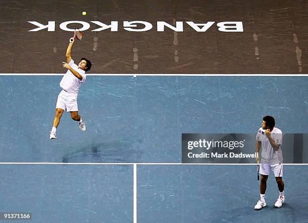 Fabrice Santoro of France hits a smash with teammate Jo-Wilfried Tsonga of France in their doubles match against Guillermo Garcia-Lopez of Spain and...