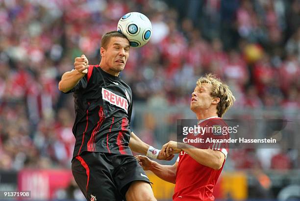 Andreas Ottl of Muenchen and Lukas Podolski of Koeln jump for a header during the Bundesliga match between FC Bayern Muenchen and 1. FC Koeln at...