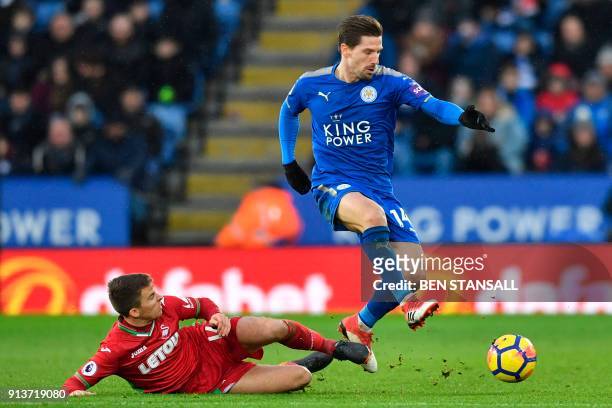 Swansea City's English midfielder Tom Carroll tackles Leicester City's Portuguese midfielder Adrien Silva during the English Premier League football...