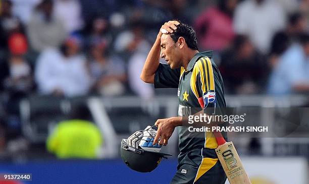 Pakistan's captain Younus Khan gestures as he walks back to pavillion after his dismissal during the ICC Champions Trophy's second semi final match...