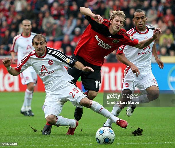 Stefan Kiessling of Leverkusen is challenged by Javier Pinola and Jawhar Mnari of Nuernberg during the Bundesliga match between Bayer Leverkusen and...