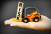 Risk evaluation concept suggested by orange forklift operating  wooden blocks