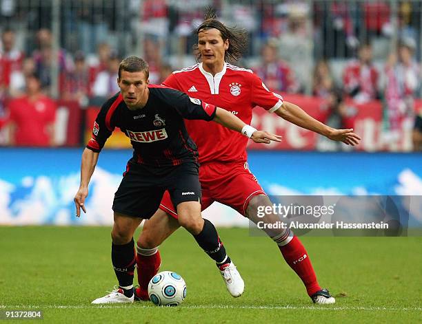 Lukas Podolski of Koeln battles for the ball with Daniel van Buyten of Muenchen during the Bundesliga match between FC Bayern Muenchen and 1. FC...