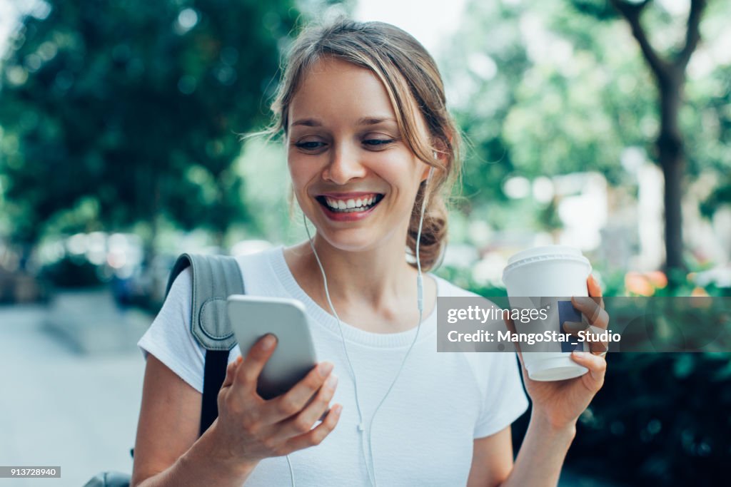 Giovane donna sorridente che ha una videochiamata all'aperto