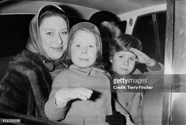Princess Margaret, Countess of Snowdon sits in the backseat of a car with her children David and Sarah and their nanny Mabel Anderson, London, UK,...