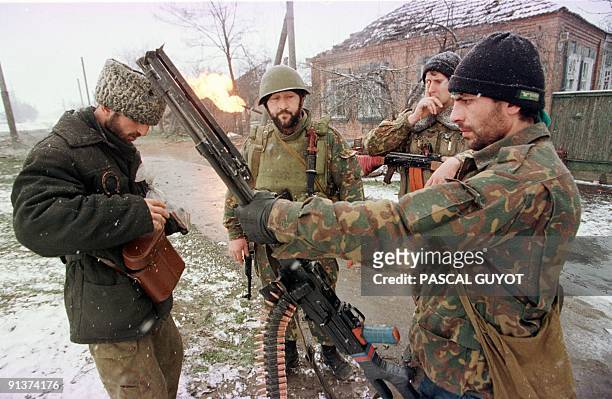 Chechen fighters carrying a machine gun head for Grozny city center 17 January as fierce fighting with Russian soldiers continue in the break-away...
