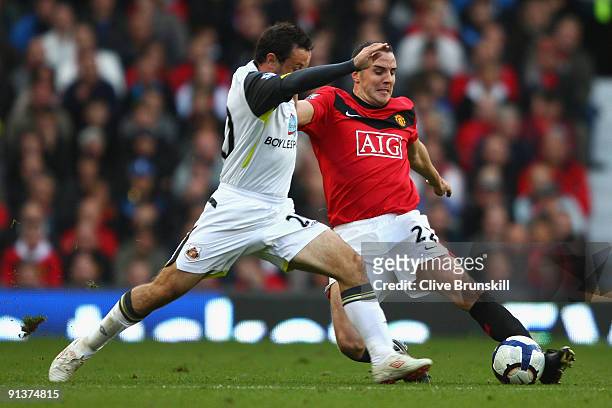 Andy Reid of Sunderland battles for the ball with John O'Shea of Manchester United during the Barclays Premier League match between Manchester United...
