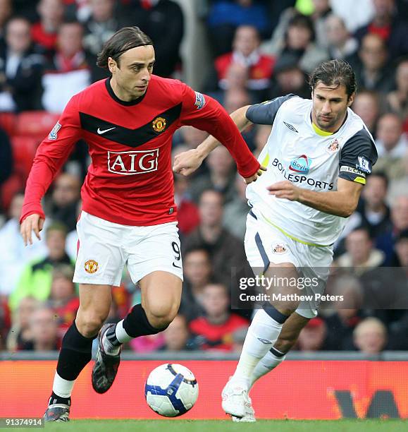 Dimitar Berbatov of Manchester United clashes with Lorik Cana of Sunderland during the Barclays Premier League match between Manchester United and...