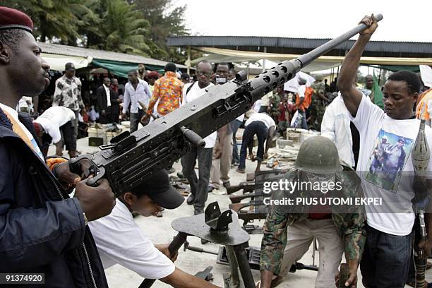 Militant youths tries to display arms and ammunition surrendered by the most notorious leader of the militant groups in the Niger Delta, Ateke Tom,...