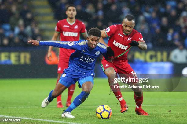 Demarai Gray of Leicester City is challenged by Jordan Ayew of Swansea during the Premier League match between Leicester City and Swansea City at the...