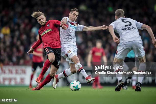 Lucas Hoeler of Freiburg is tackled by Dominik Kohr of Leverkusen during the Bundesliga match between Sport-Club Freiburg and Bayer 04 Leverkusen at...