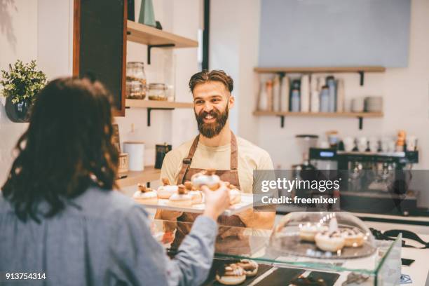 mujer joven comprar donuts - servir comida y bebida fotografías e imágenes de stock