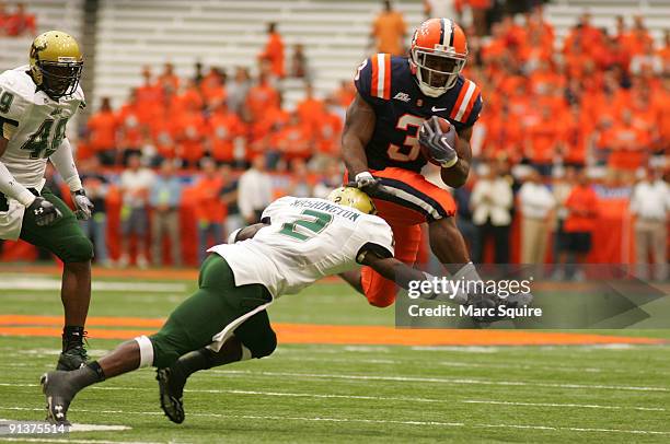 Delone Carter of the Syracuse Orange hurdles Quenton Washington of the South Florida Bulls during the game at the Carrier Dome on October 3, 2009 in...