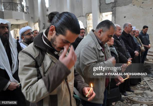 Christian worshippers cross themselves as they attend a mass held by the Syriac Orthodox Patriarch of Antioch, Ignatius Aphrem II, as they are...