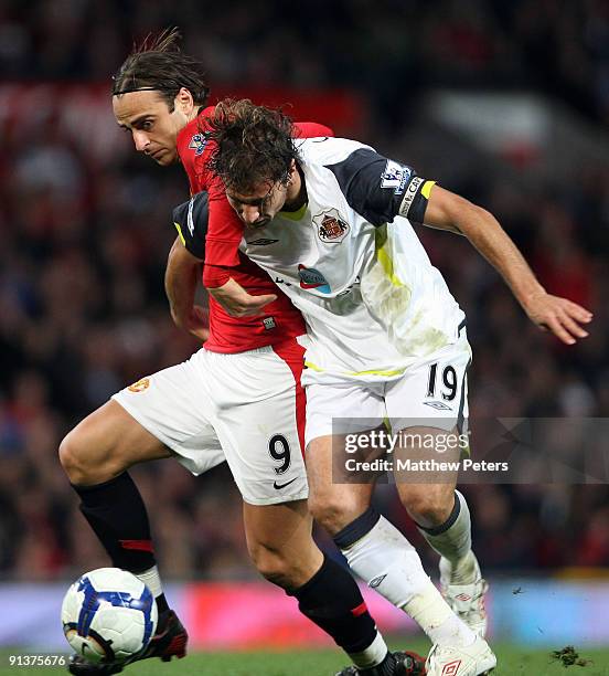 Dimitar Berbatov of Manchester United clashes with Lorik Cana of Sunderland during the Barclays Premier League match between Manchester United and...