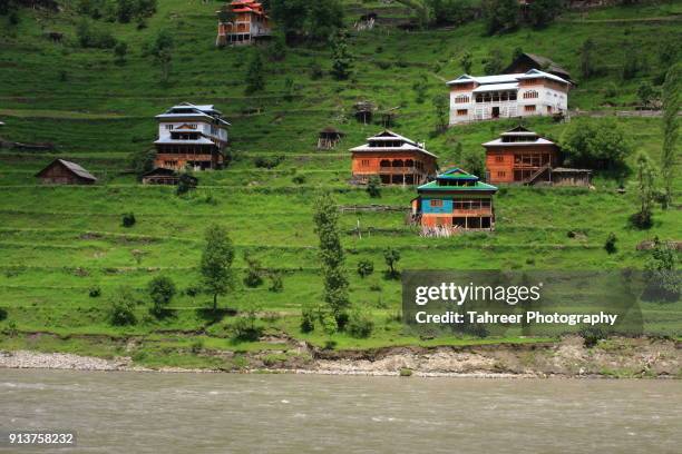 houses, fields and river in a mountainous area - pakistan stock exchange - fotografias e filmes do acervo