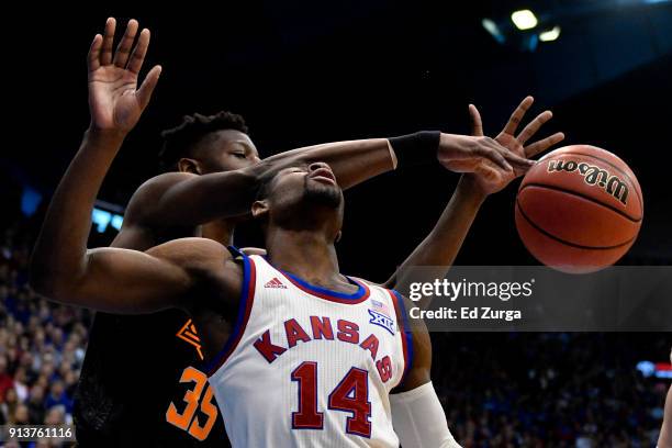 Malik Newman of the Kansas Jayhawks is fouled by Yankuba Sima of the Oklahoma State Cowboys as he takes a shot in the first half at Allen Fieldhouse...