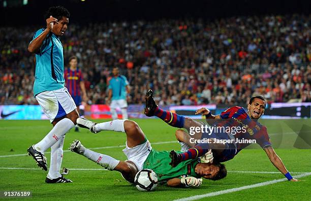 Daniel Alves of Barcelona falls over goalkeeper Diego Alves of Almeria as Wilmer Santiago of Almeria looks on during the La Liga match between...