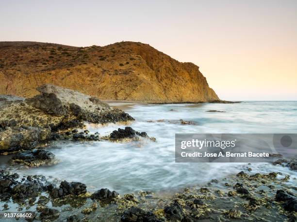 sunset on the beach and rocky coast of the cabo de gata with formations of volcanic rock.  cabo de gata - nijar natural park, cala monsul, beach, biosphere reserve, almeria,  andalusia, spain - biosphere planet earth stockfoto's en -beelden