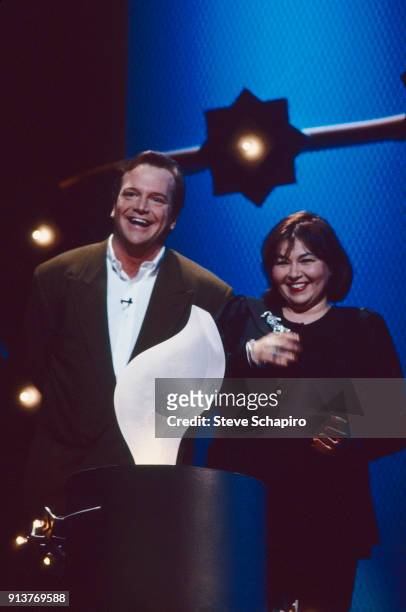 View of married American actors Tom Arnold and Roseanne Barr on stage at the Women in Film Crystal & Lucy Awards, Los Angeles, California, 1997. Barr...