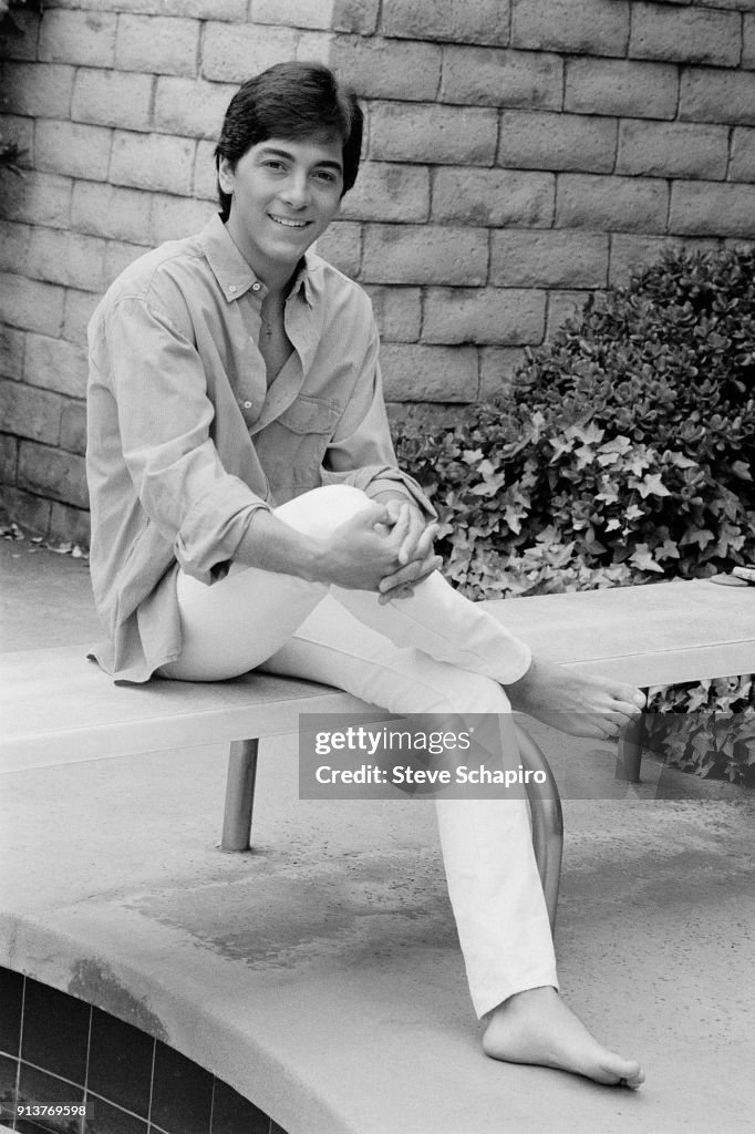 Portrait of American actor Scott Baio, as he sits on a diving board