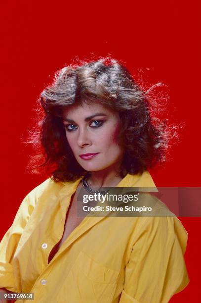 Portrait of American actress Jane Badler as she poses against a red background, Los Angeles, California, 1984.