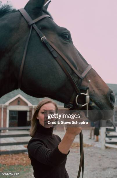 Portrait of British actress Jenny Agutter as she poses with a horse on the set of the film 'Equus' , London, England, 1976.