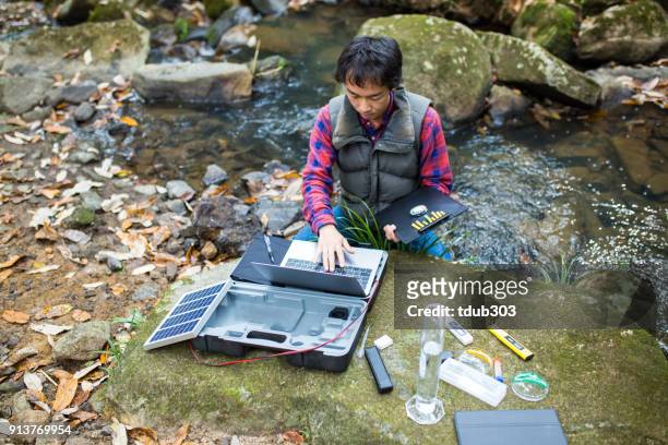 en vetenskapsman som övervakning vattenkvalitet från en solar powered fältet laboratorium - utsläppskontrollant bildbanksfoton och bilder