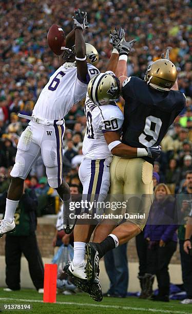 Desmond Trufant of the Washington Huskies breaks up a pass intended for Kyle Rudolph of the Notre Dame Fighting Irish as teammate Justin Glenn also...