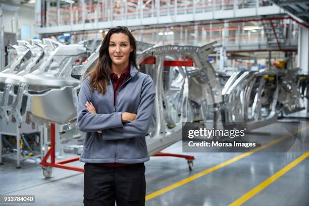 vrouwelijke ingenieur permanent tegen auto chassis - industrial portrait stockfoto's en -beelden